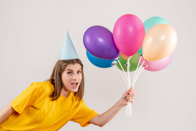庆祝手持白色气球的年轻女子乐趣情感聚会