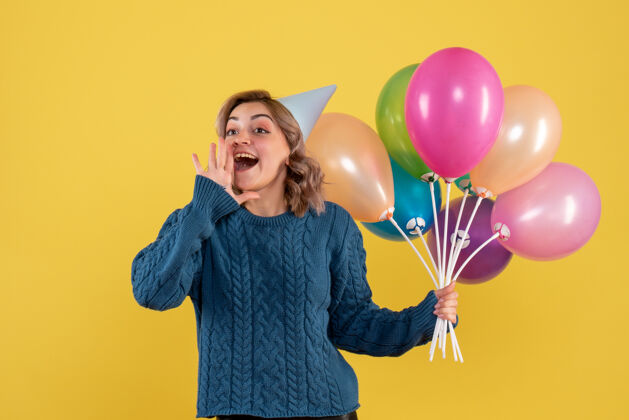 黄色手持黄色气球的年轻女性生日聚会欢乐