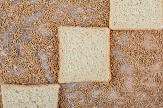 吐司大理石背景上有大麦的白吐司片美味小麦谷物
