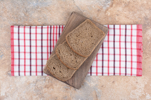 面包房用桌布把黑面包片放在木板上谷类食品切片食品