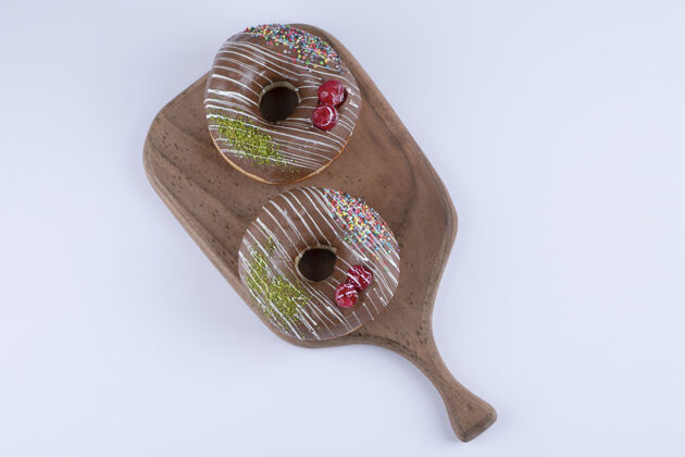 甜甜圈美味的巧克力撒在木制砧板上小吃巧克力圆