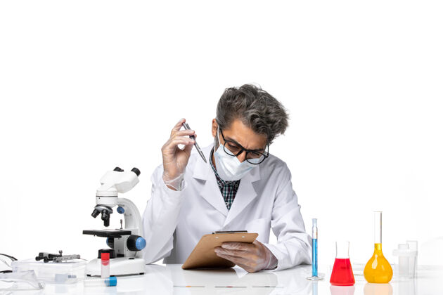 人正面图中年科学家穿着特别套装坐着写笔记实验写作科学