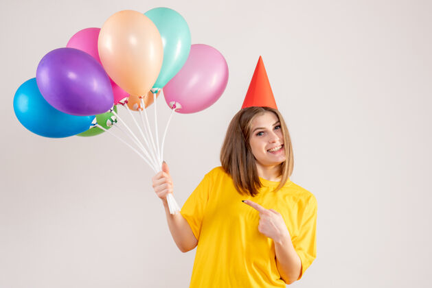 欢乐手持白色气球的年轻女子庆祝丝带生日