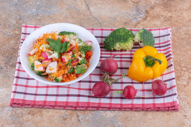 西兰花混合沙拉拼盘旁边的各种蔬菜毛巾上的大理石表面营养饮食萝卜