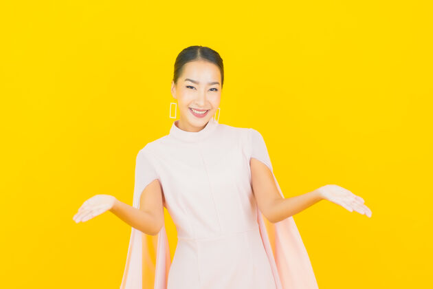 面部画像美丽的亚洲年轻女子微笑着在黄色的墙上有许多动作快乐成功人