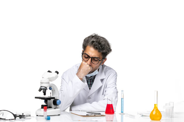化学正面图穿着特殊白色西装的中年科学家围坐在桌子旁 拿着解决方案诊所医疗外套
