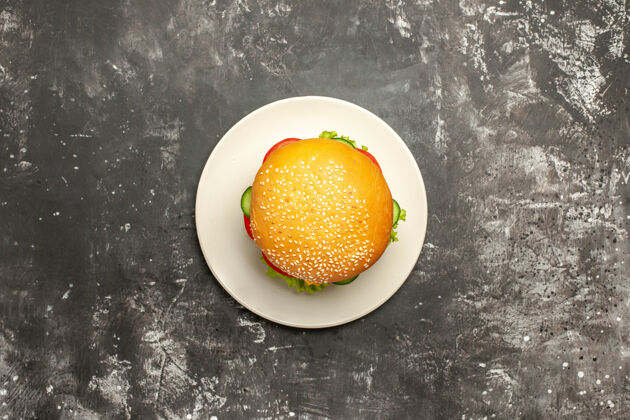 观点俯瞰美味的鸡肉汉堡和蔬菜在黑暗的表面三明治快餐面包金橘成熟馒头
