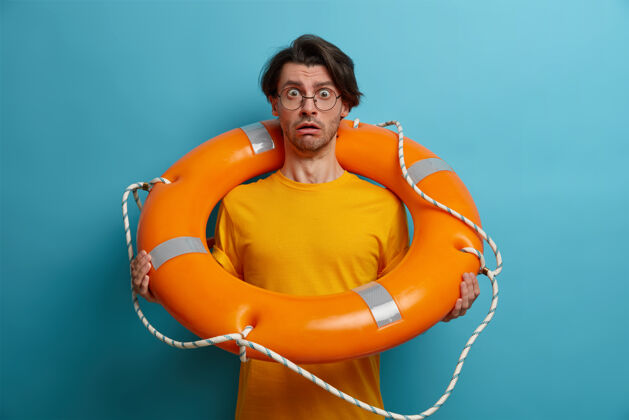 游客可怕的人害怕在深海游泳 用充气的救生圈摆姿势 听教练的建议 戴眼镜 摆姿势充气害怕眼镜