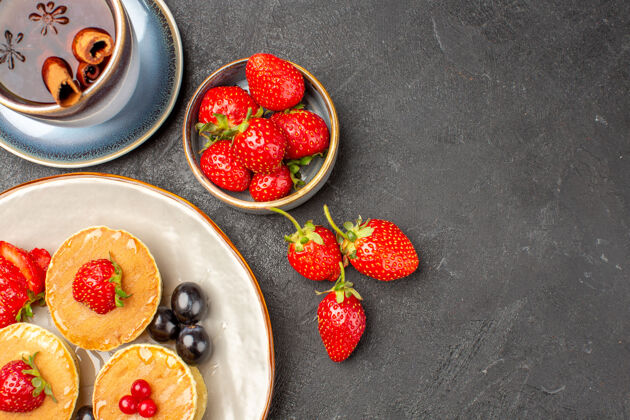 新鲜顶视图小美味的水果煎饼和一杯茶的灰色表面馅饼蛋糕水果水果多汁农产品