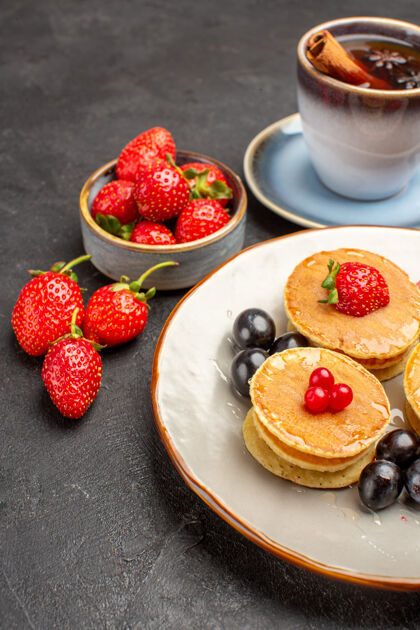 可食用的水果前视图小美味的水果煎饼和茶杯上的灰色表面馅饼蛋糕水果水果派多汁