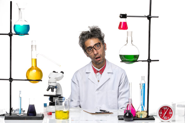 坐正面图穿着白色医疗服的中年化学家拿着溶液坐着观点化学医学