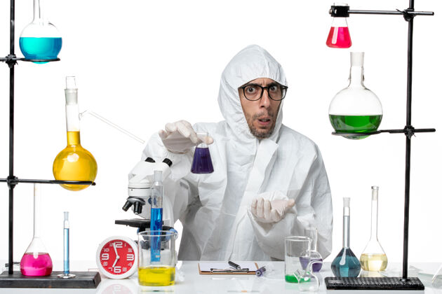病毒正面图穿着特殊防护服的男科学家拿着装有紫色溶液的烧瓶科学观点烧瓶
