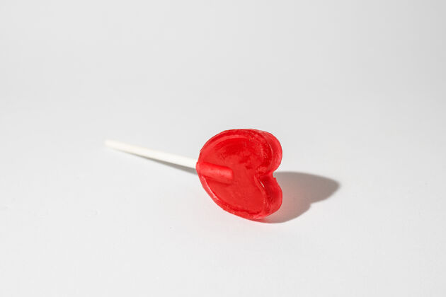 甜点特写镜头一个单一的心形棒棒糖在白色的背景吸盘糖果单一