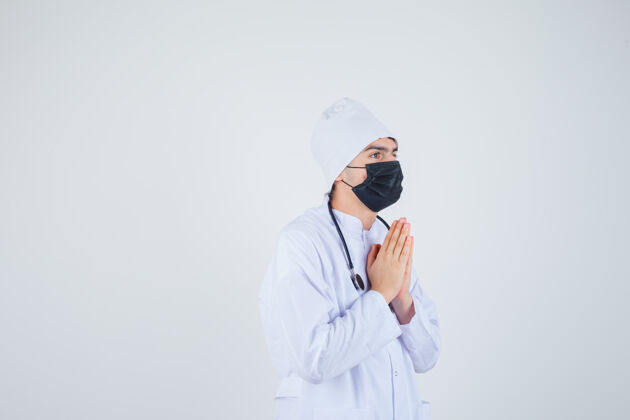 危险年轻人手牵手祈祷 身穿白色制服 戴着面具 充满希望正面图中国治疗人