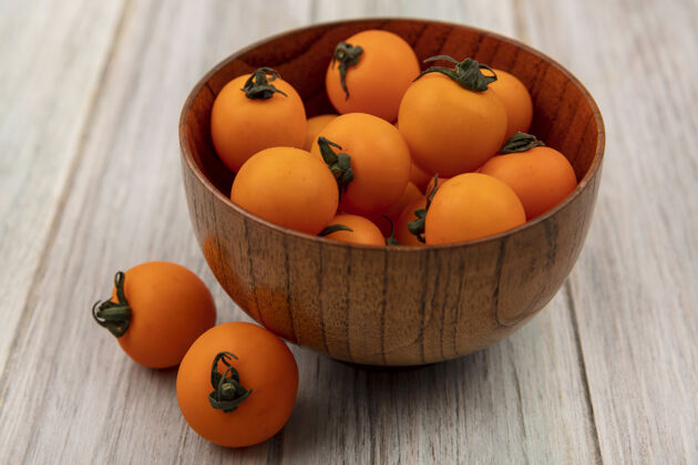 蔬菜在灰色木墙上的木碗上 可以看到美味的橙色樱桃西红柿的顶视图食品番茄新鲜