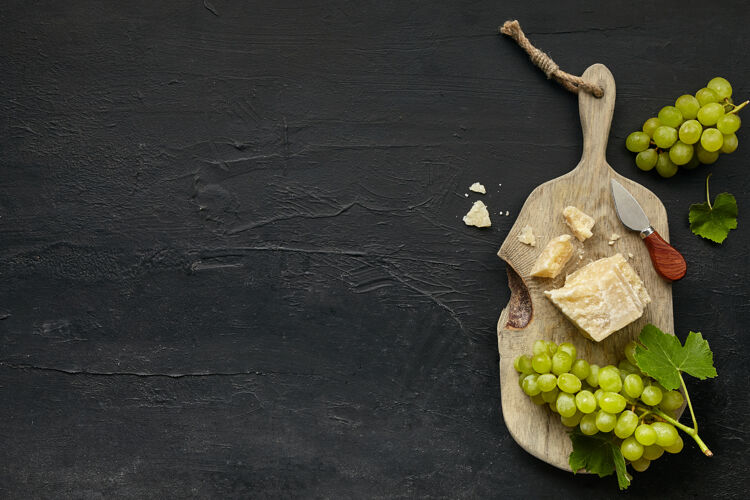 菜单顶视图美味的奶酪盘与水果 葡萄在木制厨房盘上的黑色石头背景背景深色食物
