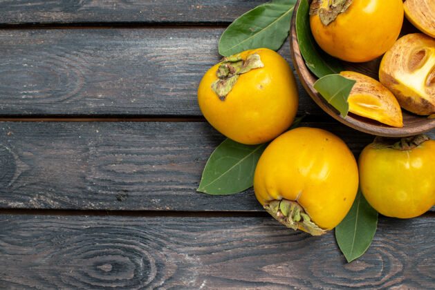 顶部顶视图新鲜甜甜的柿子放在木桌上 果实醇厚成熟黄色食物健康