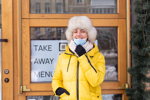 外卖食品在寒冷的冬日 快乐的年轻女子在餐厅门口 刻字 吃外卖外卖送货窗户