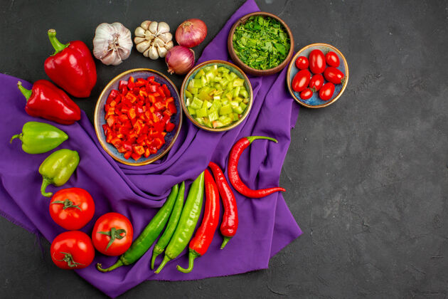 午餐顶视图不同的新鲜蔬菜和切碎的胡椒在一张深色的桌子上沙拉成熟的食物切片一餐蔬菜