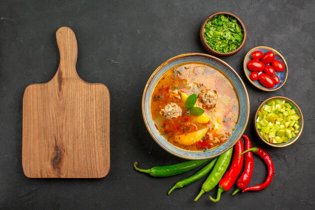 盘子俯瞰美味的肉丸汤与绿色和胡椒在一个黑暗的表酱菜的颜色酱汁胡椒沙拉