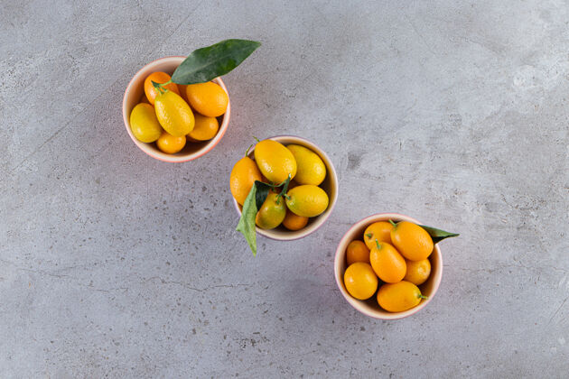 多新鲜的全柑橘类金橘果实 叶子放在碗里金橘堆的金色