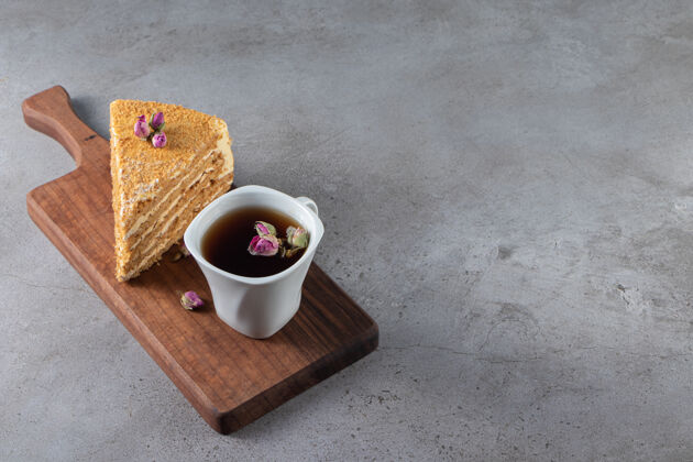 糖一块蛋糕拿破仑旁边的一杯茶放在砧板上 放在大理石桌上美味烹饪配料