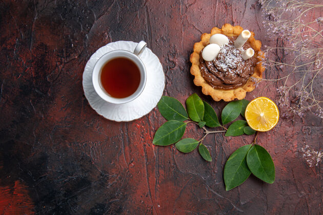 马克杯俯瞰一杯茶和美味的小蛋糕在一个黑暗的桌子饼干甜点饼干饼干咖啡茶碟