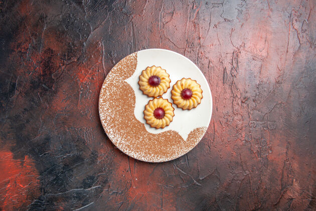 健康俯视图美味的小饼干在盘子里放在一张深色的桌子上甜甜的饼干蛋糕深色甜点柑橘