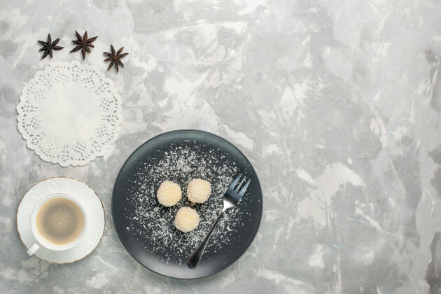 玻璃杯俯瞰美味的椰子糖和咖啡在白色的表面椰子邦邦生的