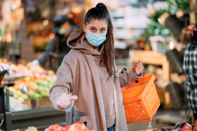 生病戴着防护面具的年轻女子在超市购物女人防护预防