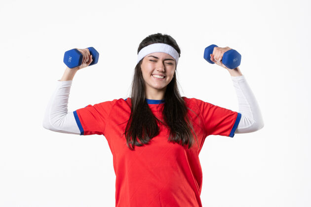 人正面图快乐的年轻女性穿着运动服 用哑铃锻炼身体青年工作青少年