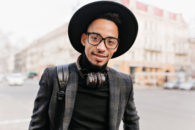 广场迷人的非洲男人 黑眼睛 微笑着户外肖像的黑人年轻人在街上摆姿势城镇时尚帽子