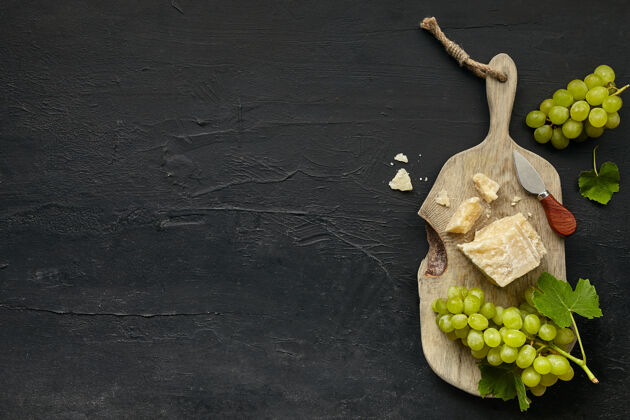 菜单顶视图美味的奶酪盘与水果 葡萄在木制厨房盘上的黑色石头背景背景深色食物