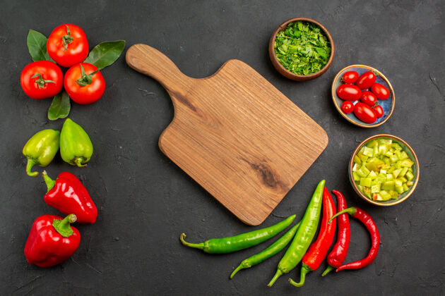 素食顶视图新鲜蔬菜西红柿和甜椒放在深色桌子上沙拉成熟的餐色甜椒膳食颜色