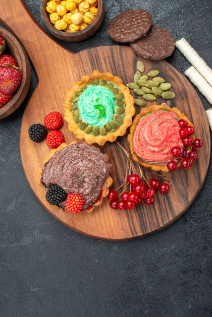食品俯瞰美味的奶油蛋糕和水果在黑暗的桌子上甜甜的饼干饼干水果糖果草莓