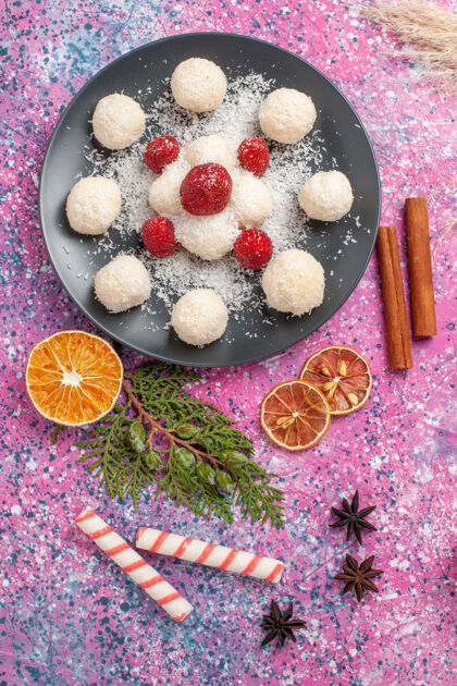 草莓美味的椰子糖和新鲜的红色草莓在粉红色的表面俯视图饼干甜点椰子