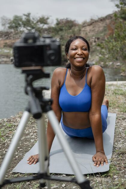 相机在外面教瑜伽姿势的年轻女子姿势女人人体