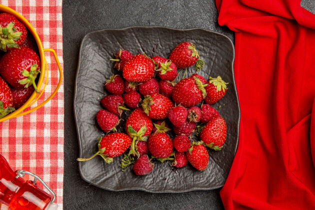 健康顶视图新鲜的红色草莓放在一个深色的桌子上 颜色是覆盆子果深色美味美味