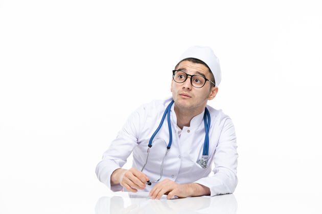 药品正面图：男医生穿着医疗服坐在桌子后面医院护士医生