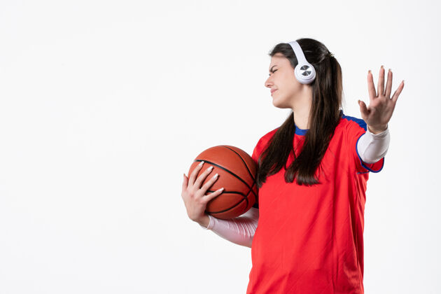 视图前视图使穿着运动服的年轻女子对篮球不满意人成人微笑