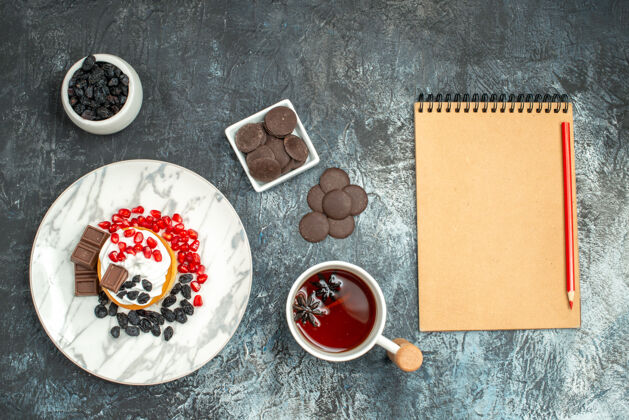 饼干顶视图美味的奶油蛋糕与巧克力饼干和一杯茶在一个光明黑暗的背景帽子派盖子