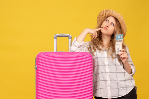 人俯视图：戴着帽子的年轻女士展示着车票 站在她粉红色的包旁边上衣小姐购物