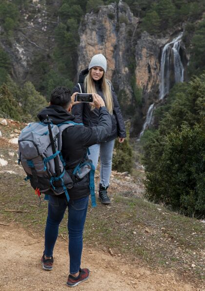 高山大自然中的情侣用手机拍照年轻科技探索