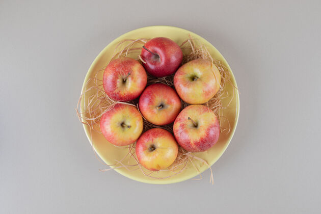 多汁苹果和稻草放在大理石上的碗里风味碗健康