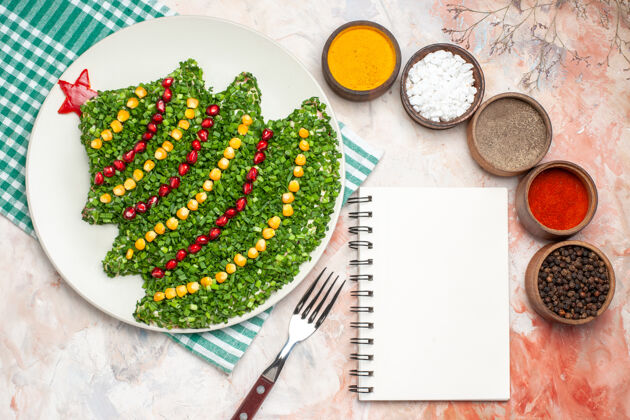 胡椒顶视图美味的绿色沙拉在新年树形状与调味品在轻背景灯光形状年