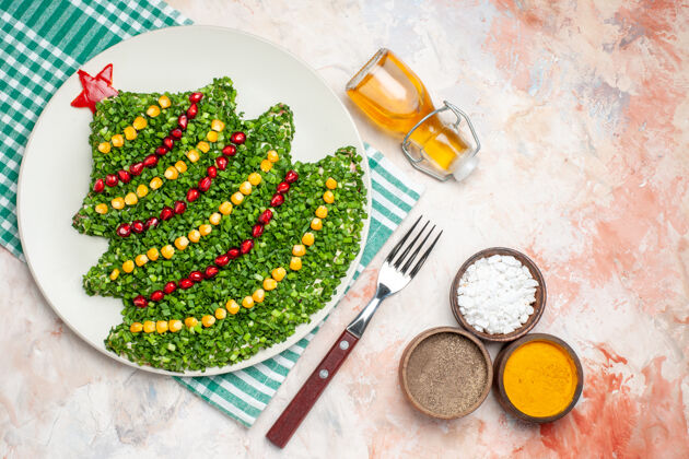 食物顶视图美味的绿色沙拉在新年树形状与调味品在轻背景胡椒午餐盘子
