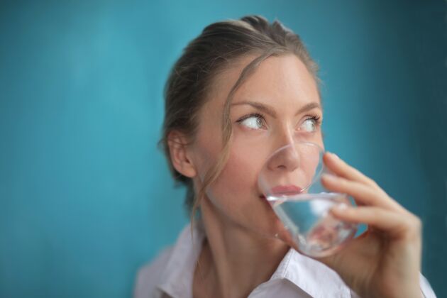 水特写镜头美丽的女性饮用水的蓝色漂亮健康手