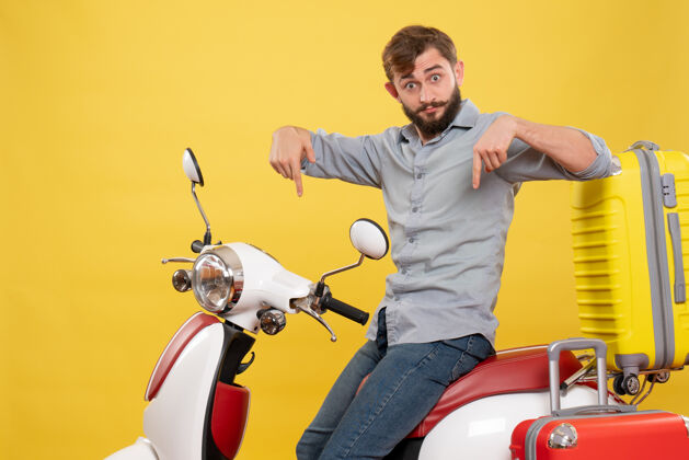 旅行旅游概念与年轻的情感胡须男子坐在摩托车上指着黄色自行车人年轻人