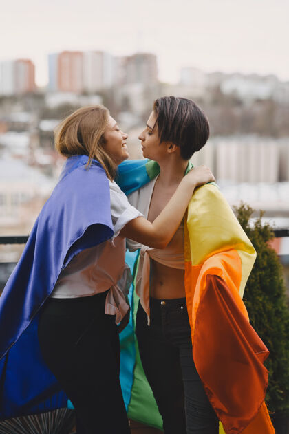 情侣Lgbt旗帜靠近女孩非传统取向的女孩女同性恋的拥抱关怀同性恋手