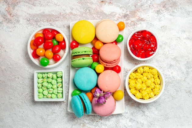 糖果顶视图彩色美味麦卡龙小蛋糕与糖果的白色空间颜色生的茶
